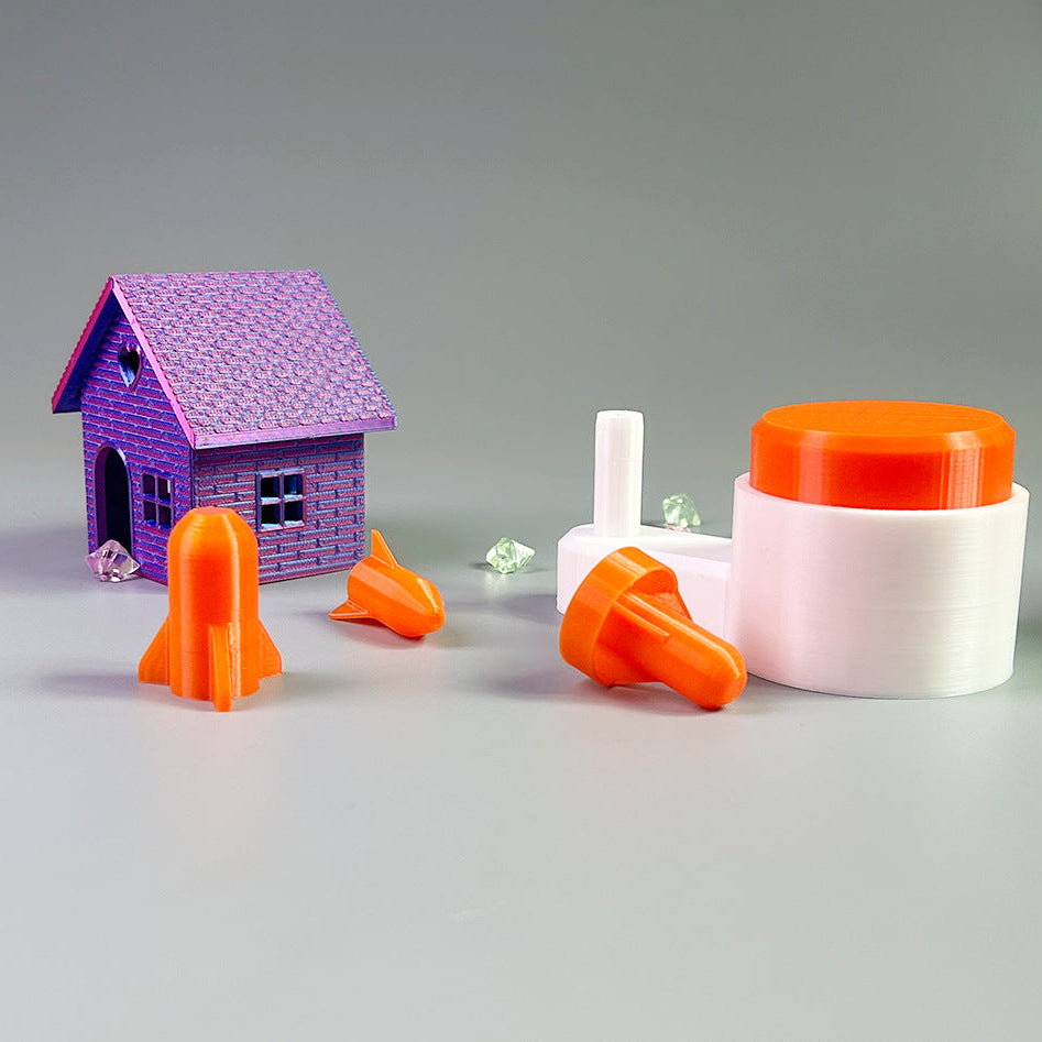 Toy house with rocket and space-themed items on a gray background