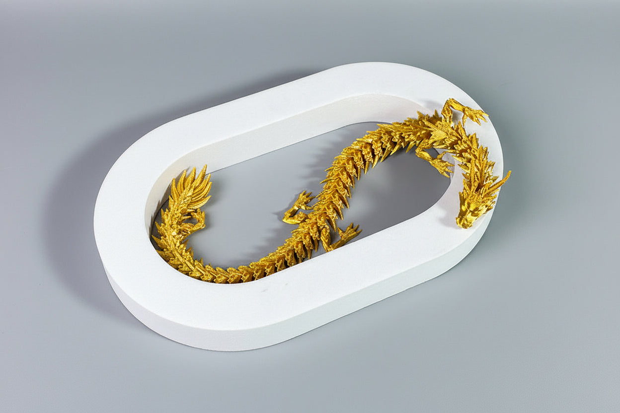 Gold dragon toy on a white base with gray background