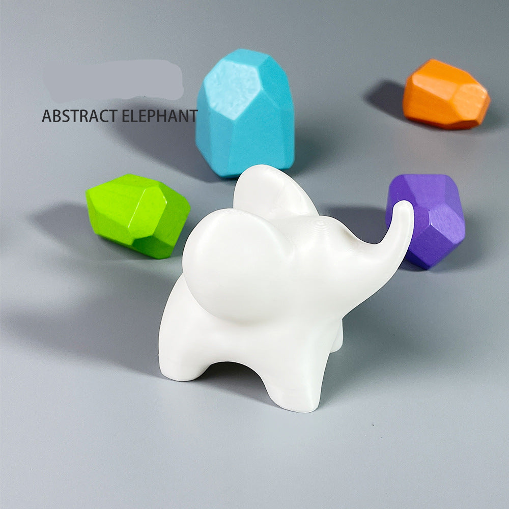 White abstract elephant figurine with colorful geometric blocks on a gray background