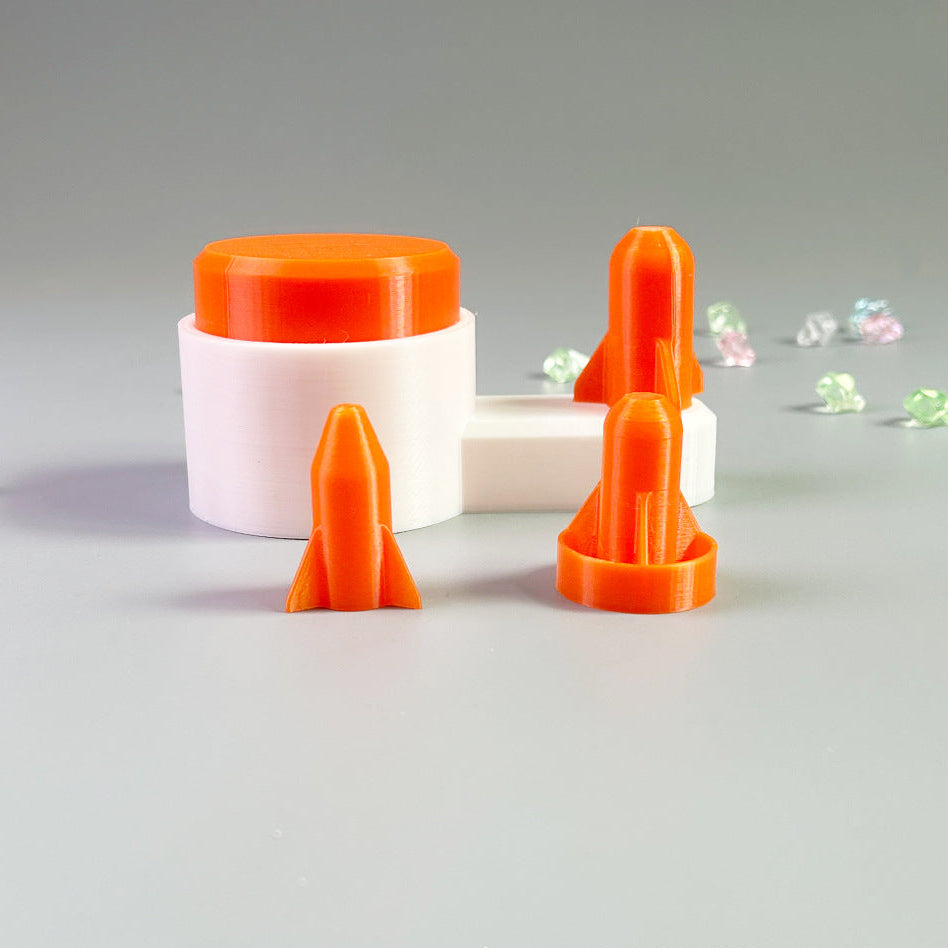 Orange rocket-shaped objects on a gray surface with a blurred background
